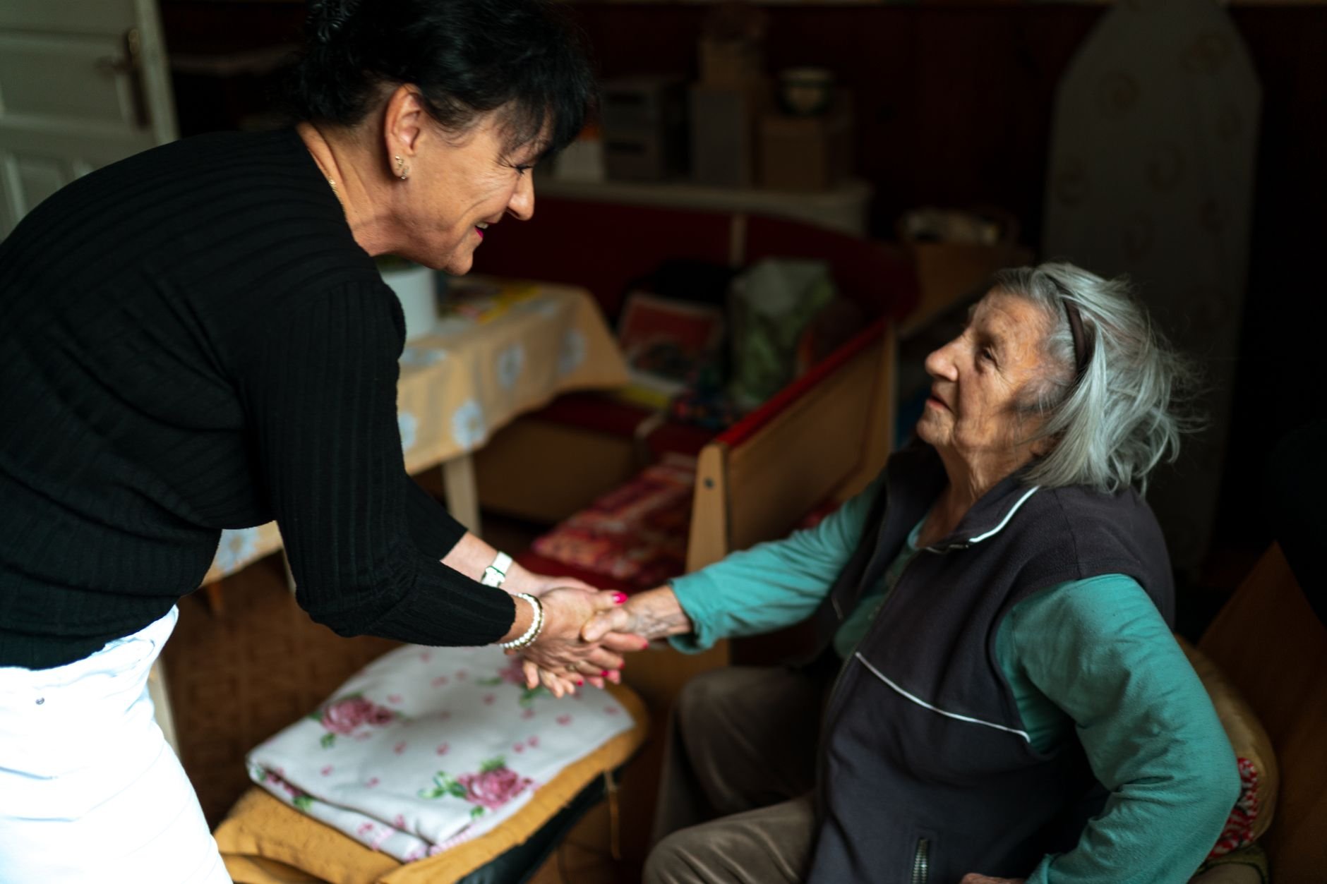 Dos mujeres, una mayor y su cuidadora, compartiéndose el tiempo en casa con calidez